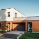 Modern house with white and wooden facade, flat roof, and garage entrance.