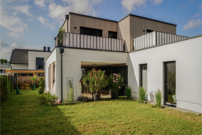 Contemporary two-story house with flat roof and landscaped garden.